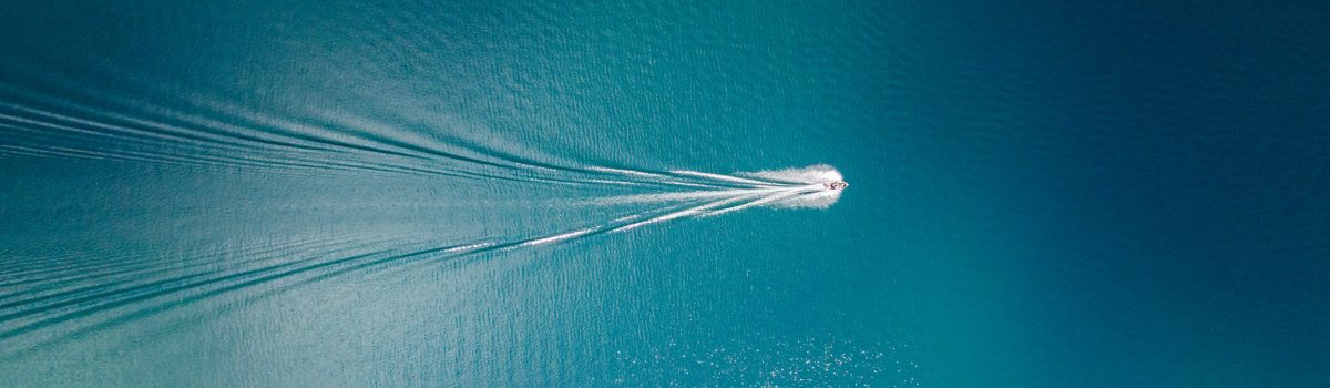 Drone view of a boat sailing across the blue clear waters of lake Tahoe California Drone view of a boat sailing across the blue clear waters of lake Tahoe California